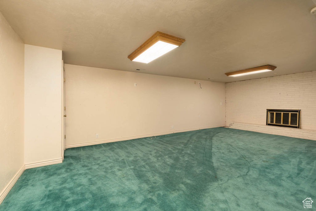 Finished basement with carpet flooring and a fireplace