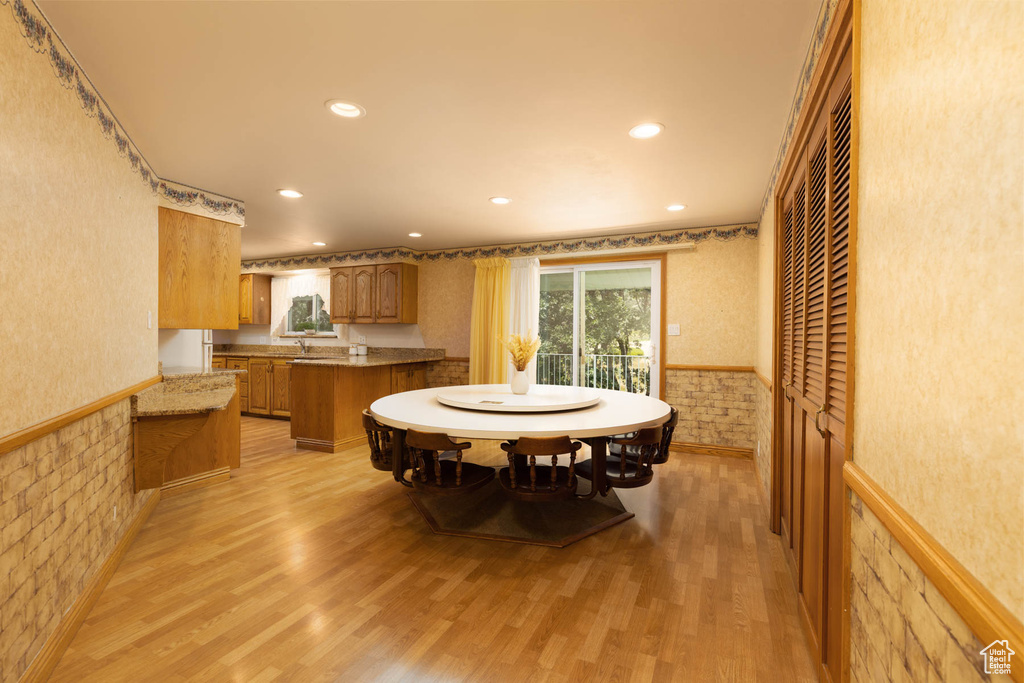 Dining room featuring light wood-style floors, recessed lighting, and wainscoting