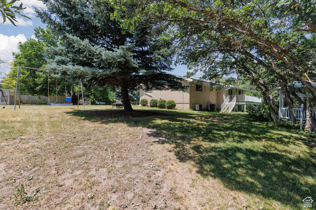 View of grassy yard featuring stairway