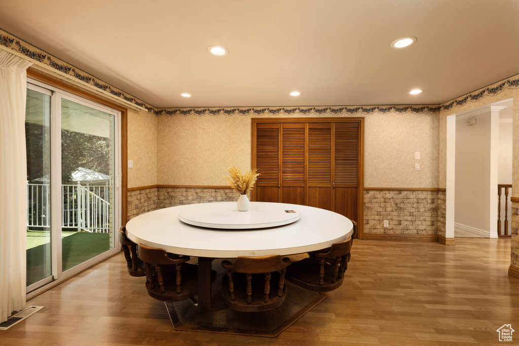 Dining area featuring wainscoting, recessed lighting, wallpapered walls, and wood finished floors
