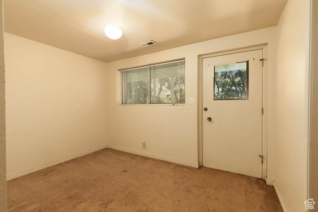 Unfurnished room featuring healthy amount of natural light and light colored carpet
