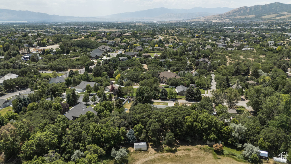 Aerial view of property and surrounding area featuring a mountainous background