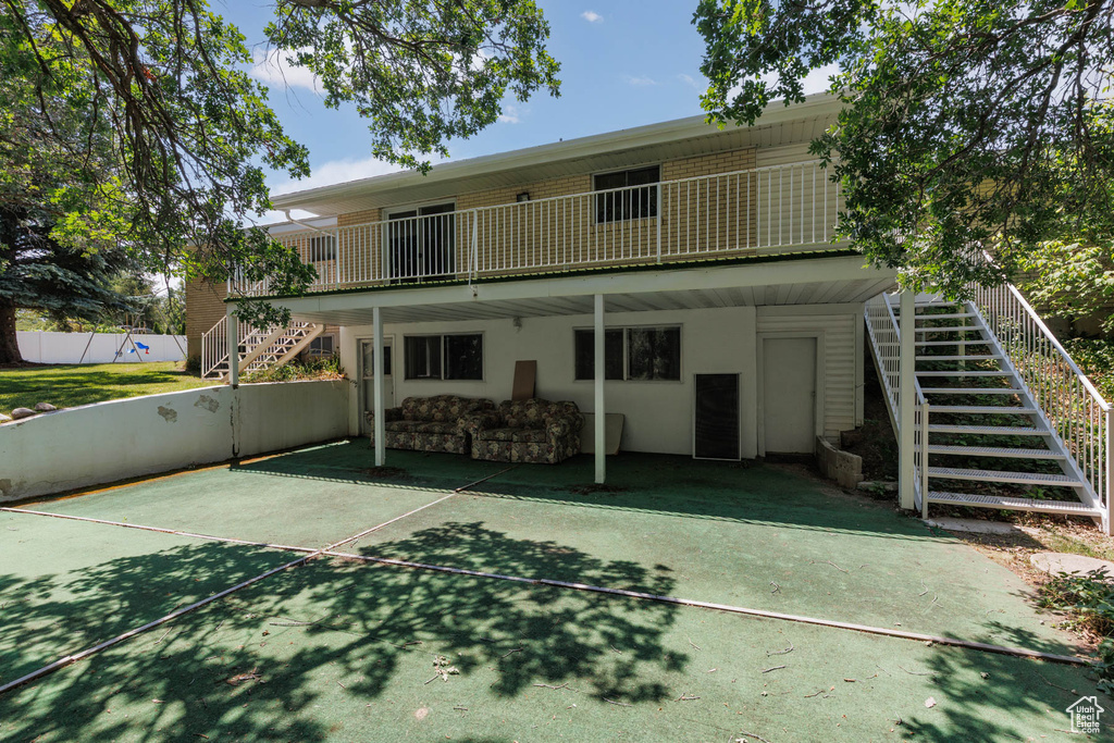 Rear view of house featuring stairs and stucco siding