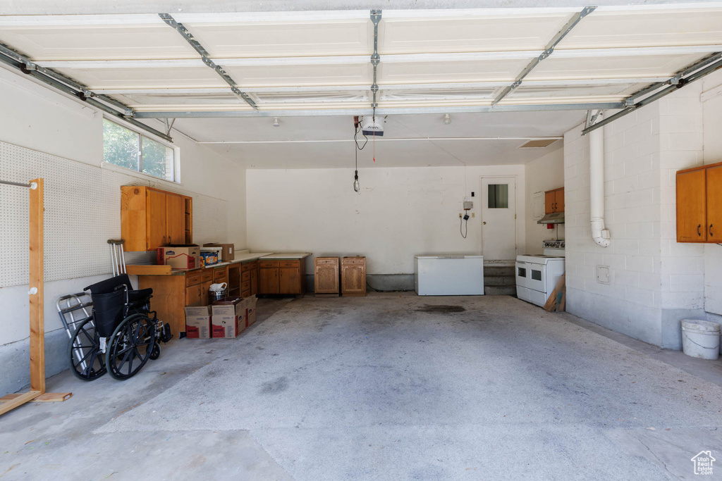 Garage with freestanding refrigerator and a garage door opener