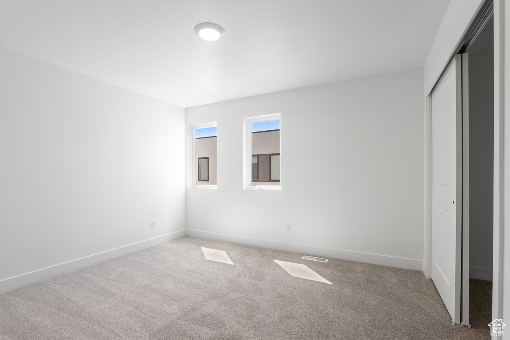 Unfurnished bedroom with carpet flooring and a closet