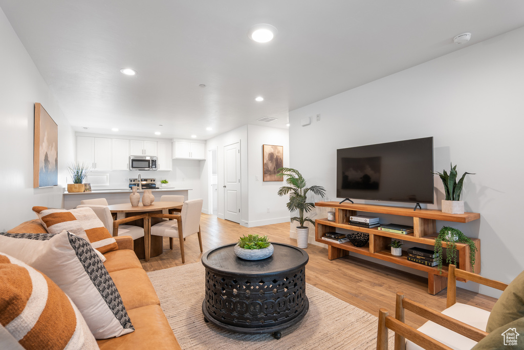 Living area featuring recessed lighting and light wood-style flooring