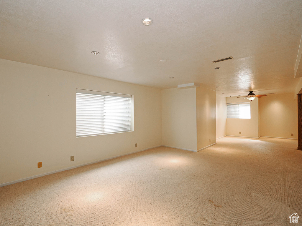 Spare room featuring a ceiling fan and light colored carpet