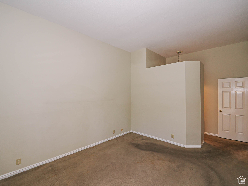 Spare room with carpet floors and vaulted ceiling