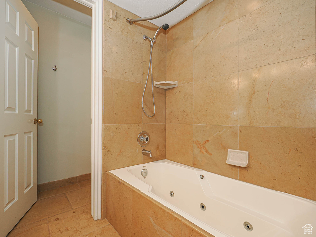 Bathroom with a combined bath / shower with jetted tub and tile patterned floors