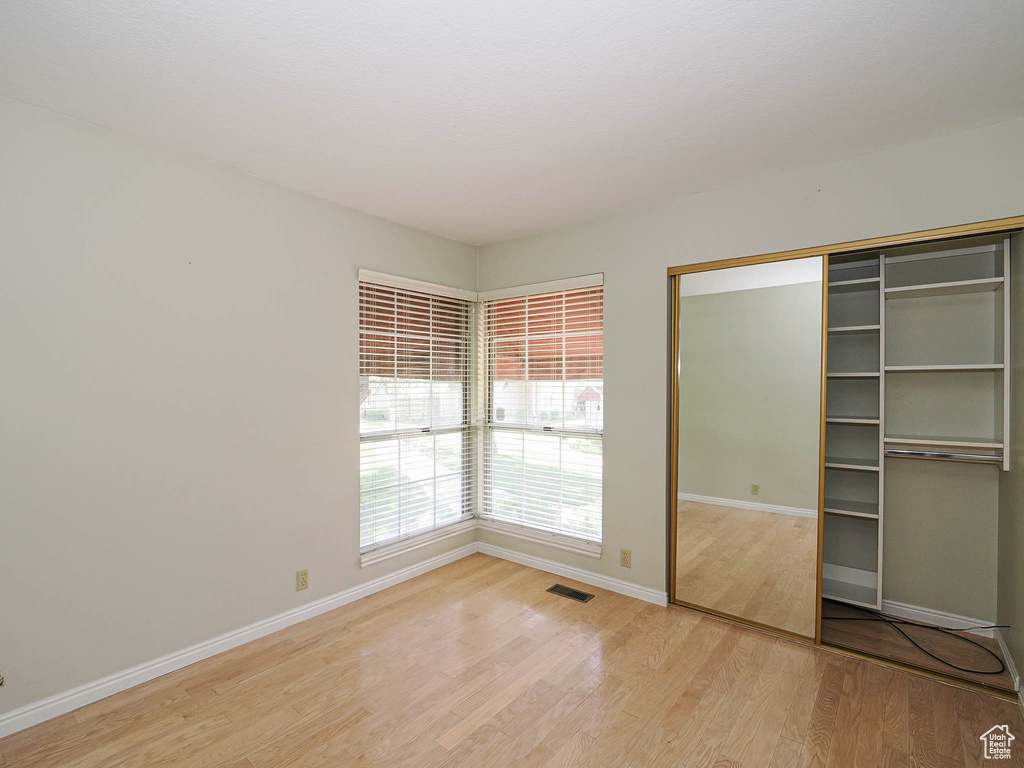 Unfurnished bedroom featuring light wood-style flooring and a closet