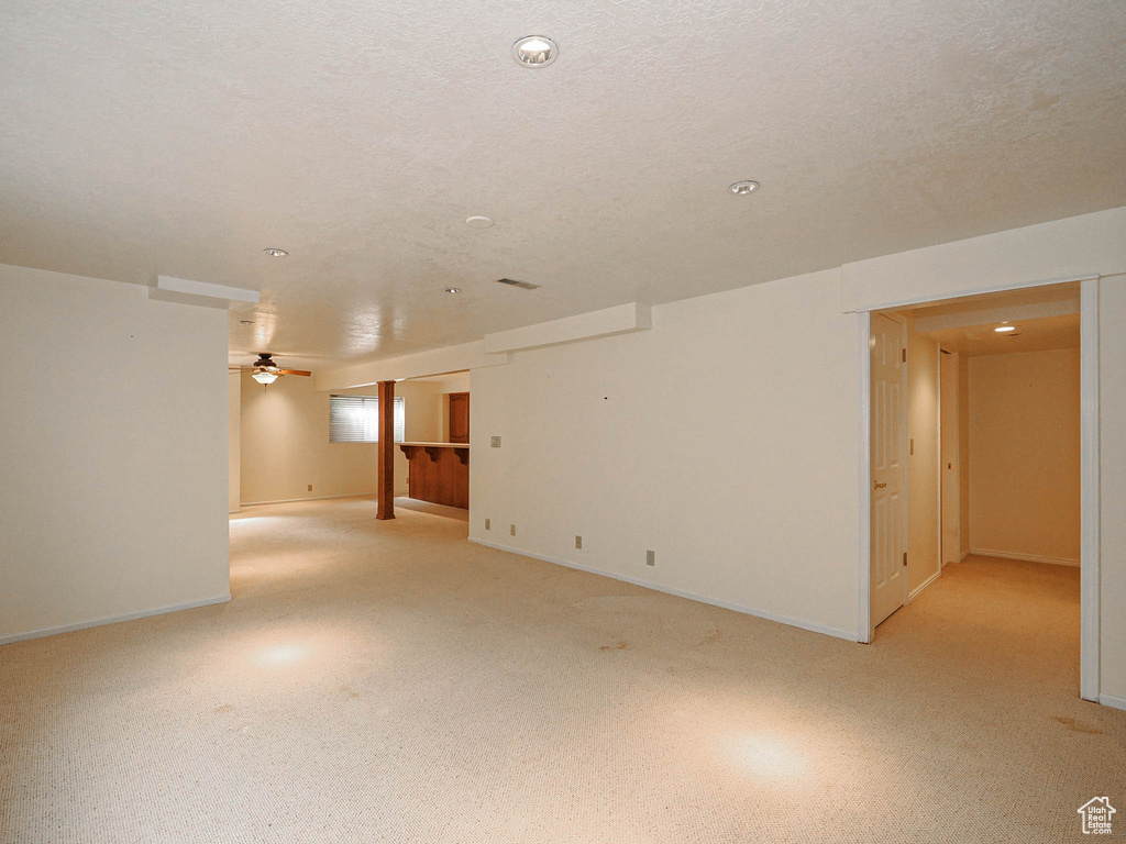 Empty room featuring ceiling fan and light colored carpet