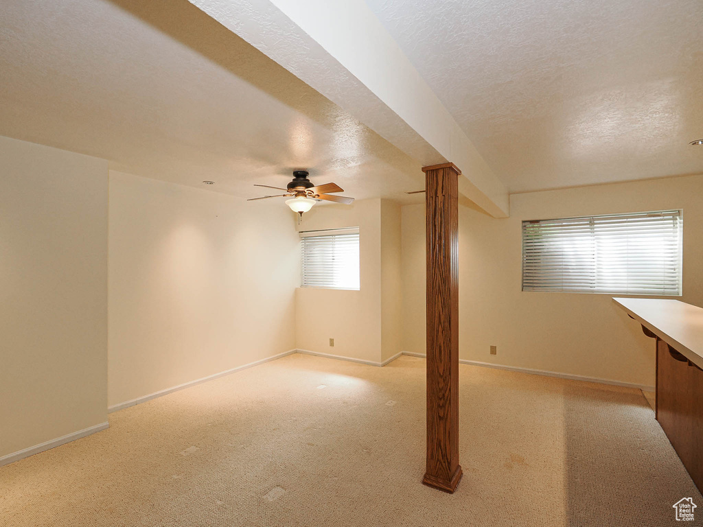 Spare room with light carpet, a textured ceiling, and a ceiling fan