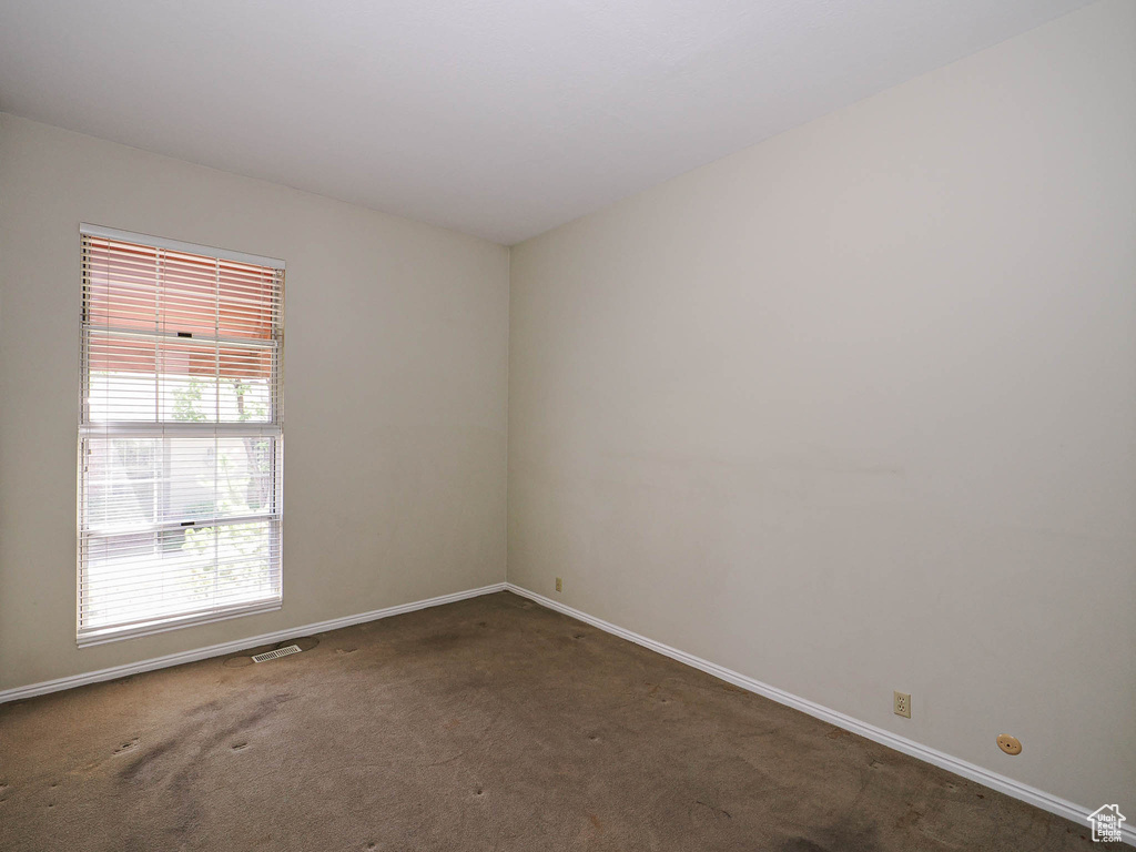 Empty room featuring carpet floors and baseboards