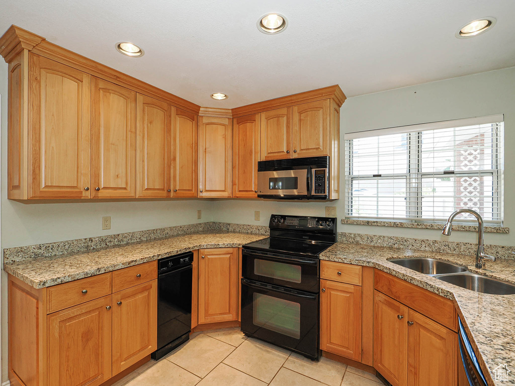 Kitchen featuring stainless steel appliances, light tile patterned floors, recessed lighting, and light stone counters