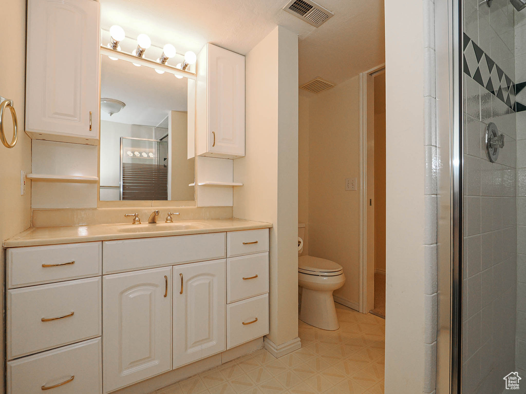 Bathroom with a stall shower, vanity, and tile patterned floors