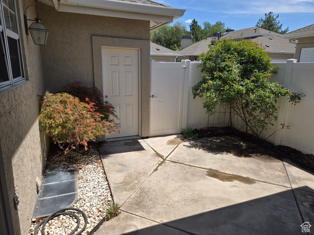 Property entrance featuring stucco siding, a gate, and a patio