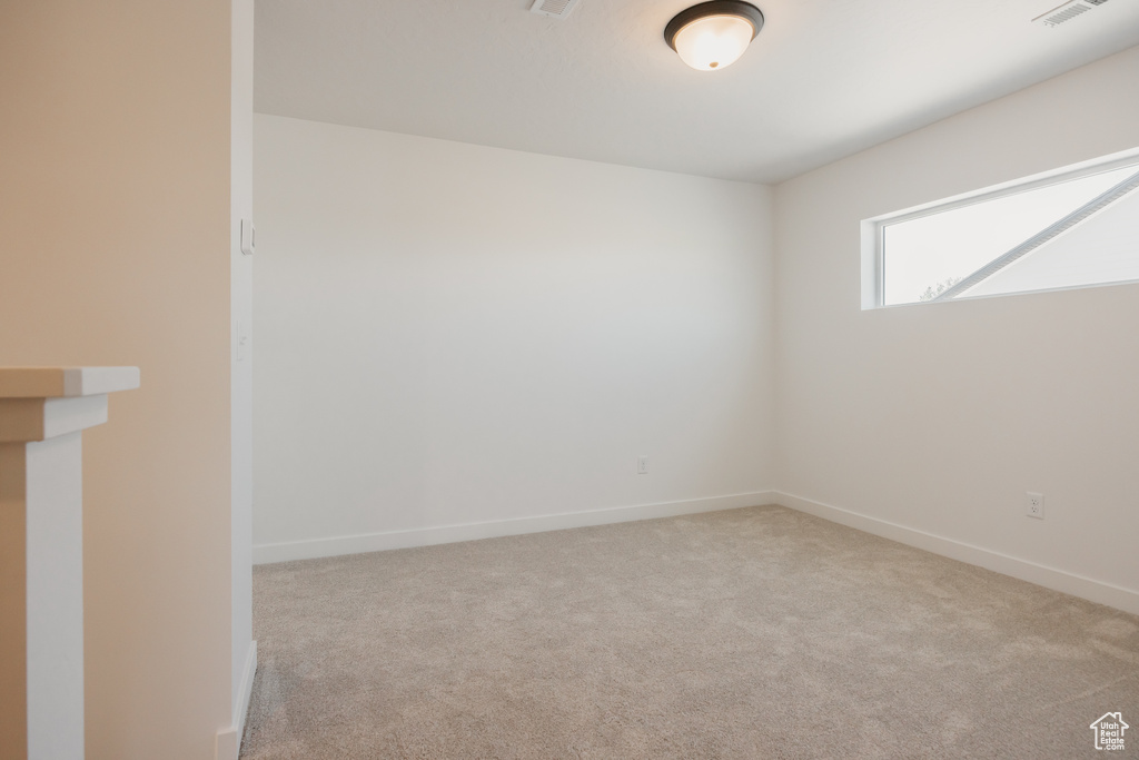 Carpeted spare room featuring baseboards