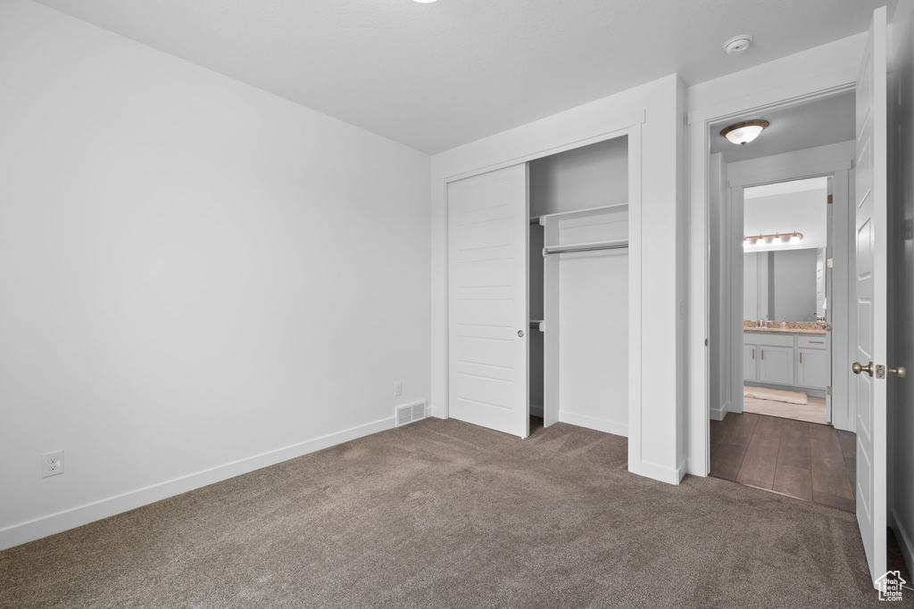 Unfurnished bedroom with carpet and a closet