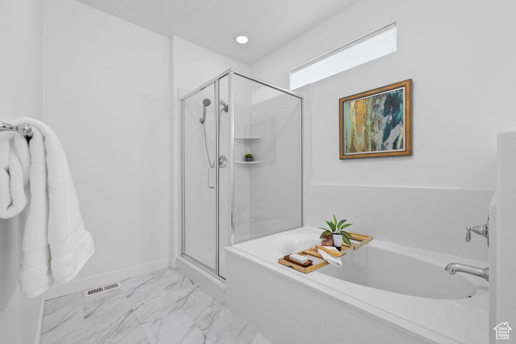 Bathroom with a bath, a stall shower, and marble look tiles
