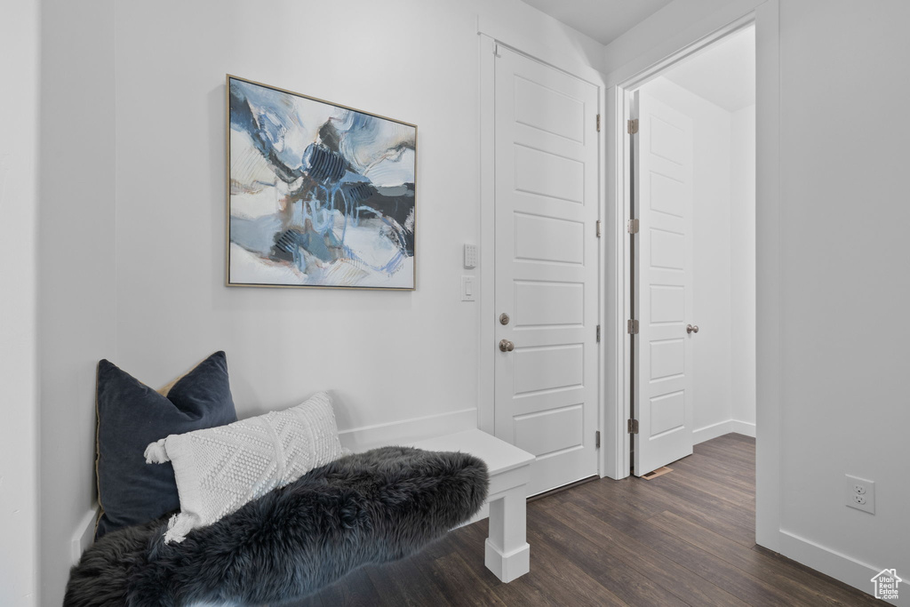 Living area with baseboards and dark wood-type flooring