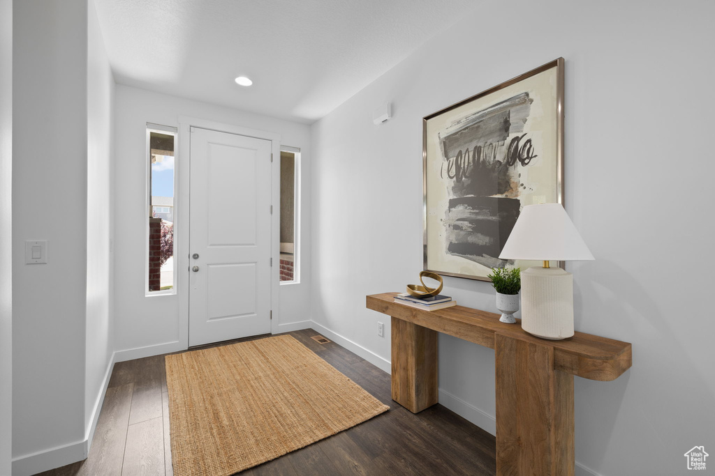 Foyer entrance with wood finished floors and recessed lighting