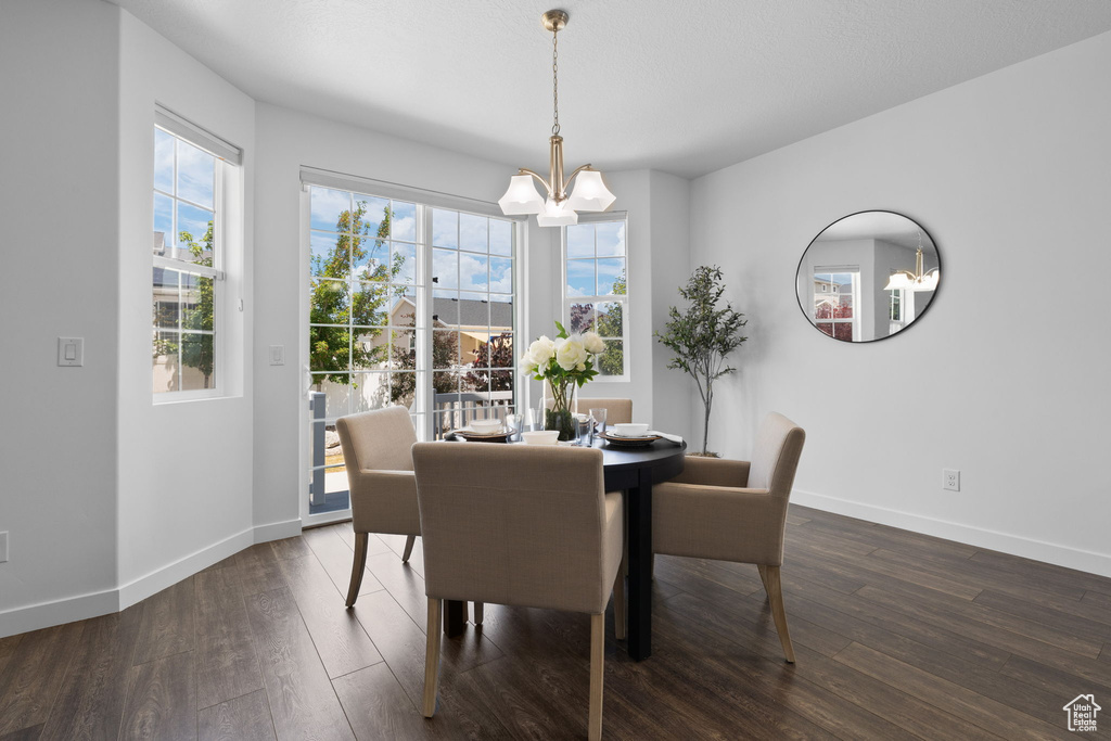 Dining area featuring a chandelier and dark wood-style floors