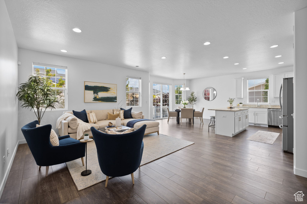 Living area featuring recessed lighting, dark wood-style flooring, and a textured ceiling