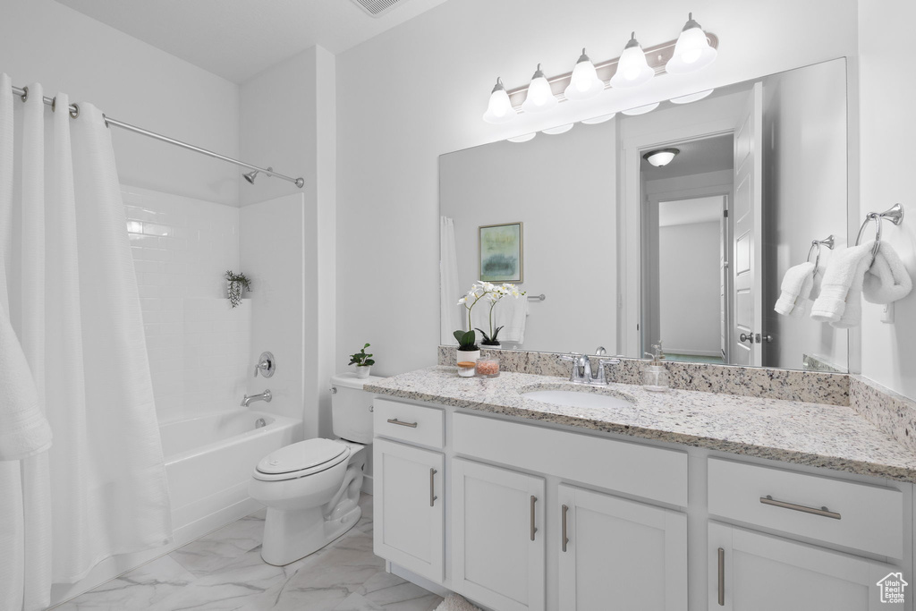 Full bath featuring shower / tub combo, vanity, and marble finish floors