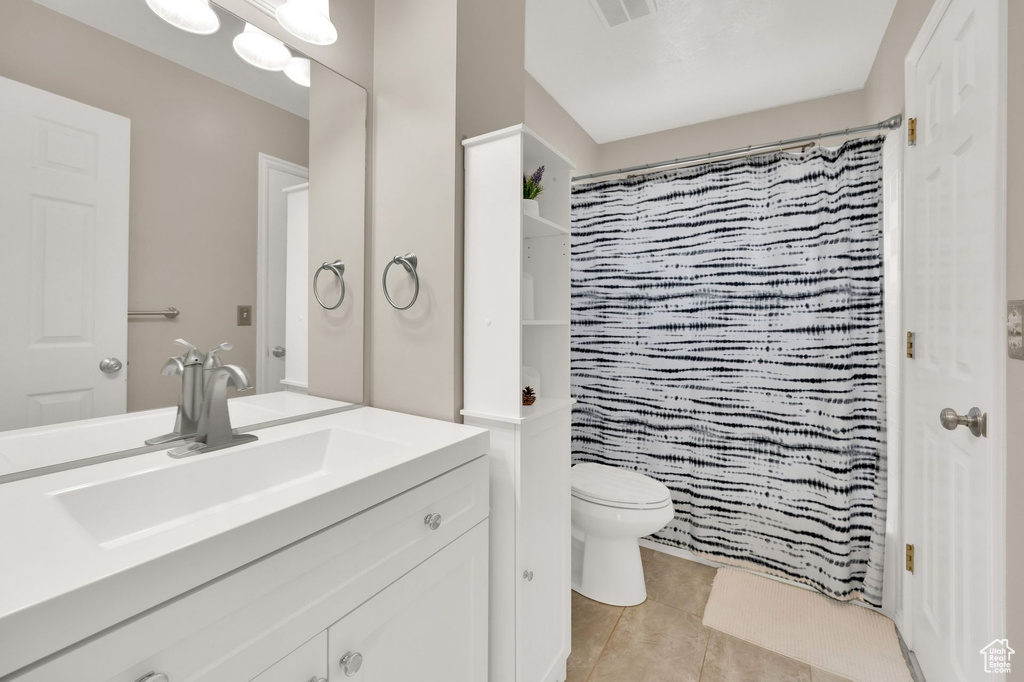 Bathroom with vanity, tile patterned flooring, and a shower with shower curtain