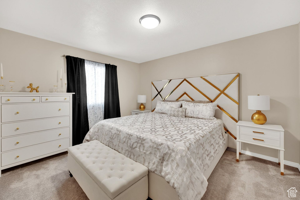 Bedroom with light colored carpet and baseboards