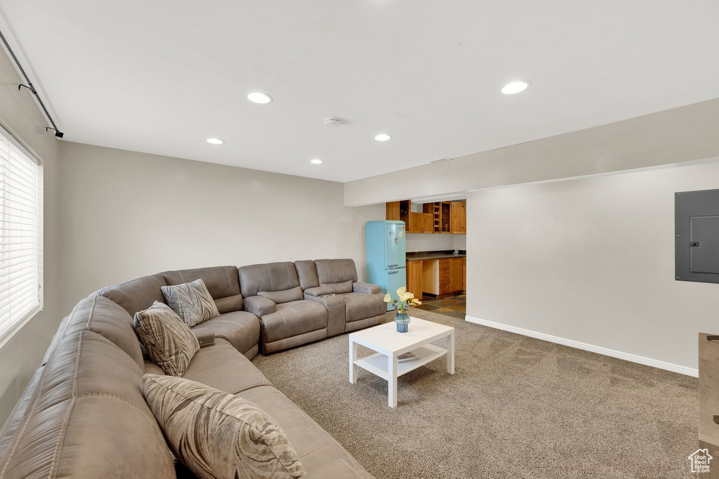 Living room with electric panel, recessed lighting, and carpet