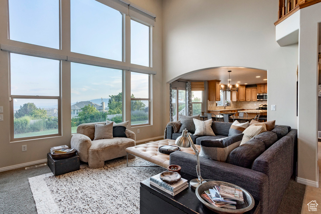 Living area featuring arched walkways, a chandelier, a towering ceiling, a mountain view, and recessed lighting