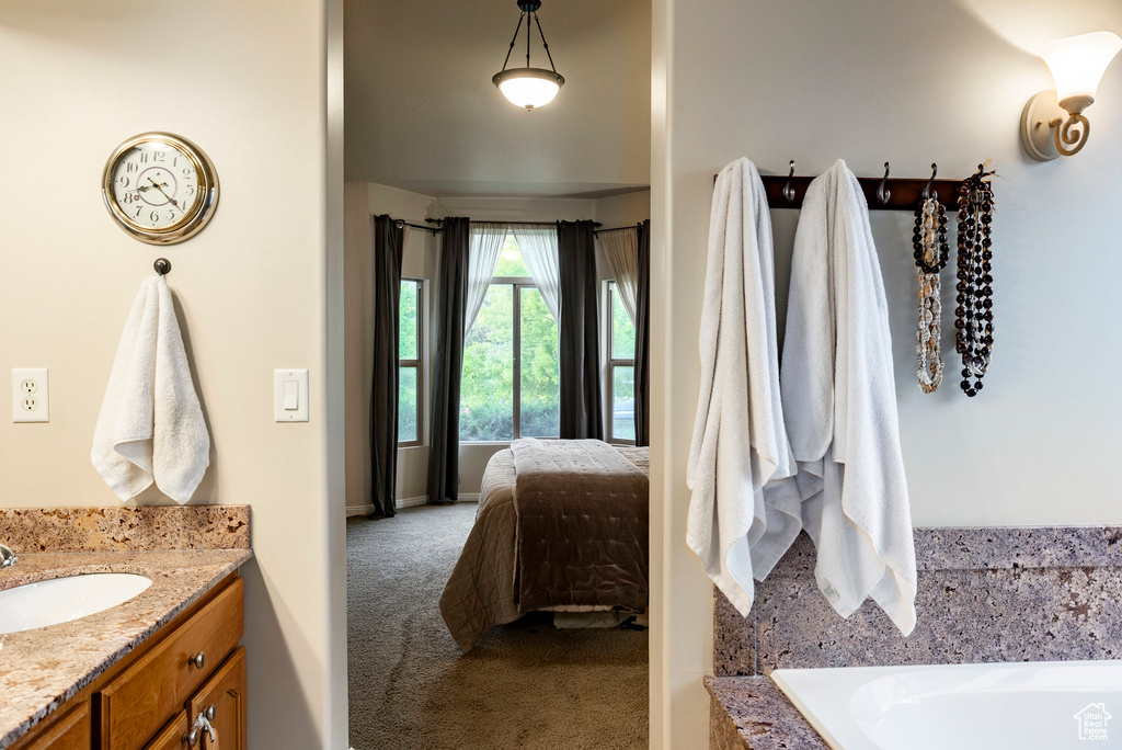 Ensuite bathroom with a tub to relax in and vanity