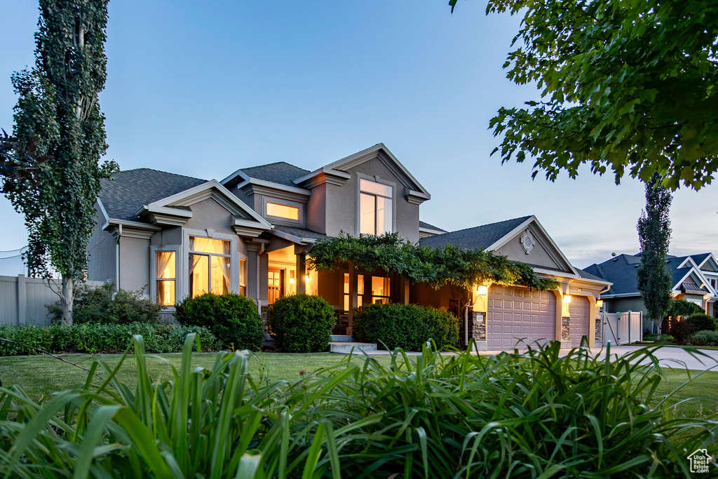 View of front of home with a garage, stucco siding, a shingled roof, and concrete driveway