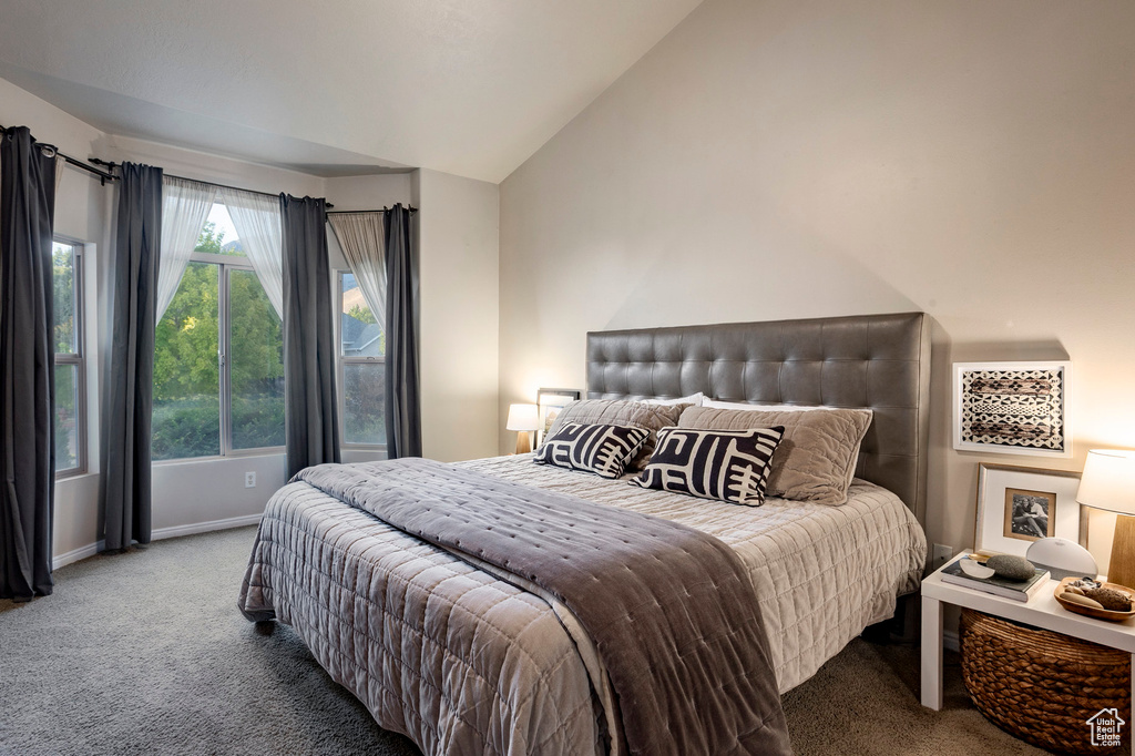 Carpeted bedroom featuring lofted ceiling and baseboards