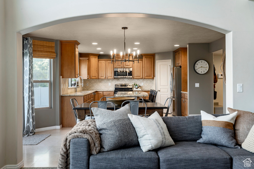 Living room featuring arched walkways, a chandelier, recessed lighting, and light tile patterned flooring