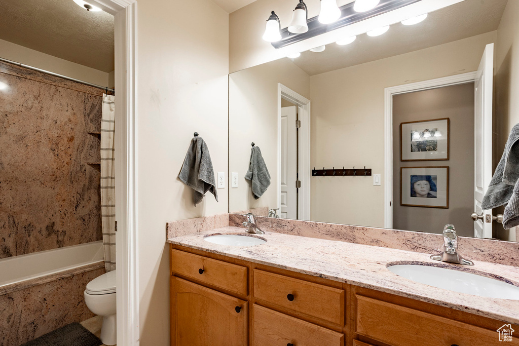 Full bathroom with double vanity and shower / bath combo