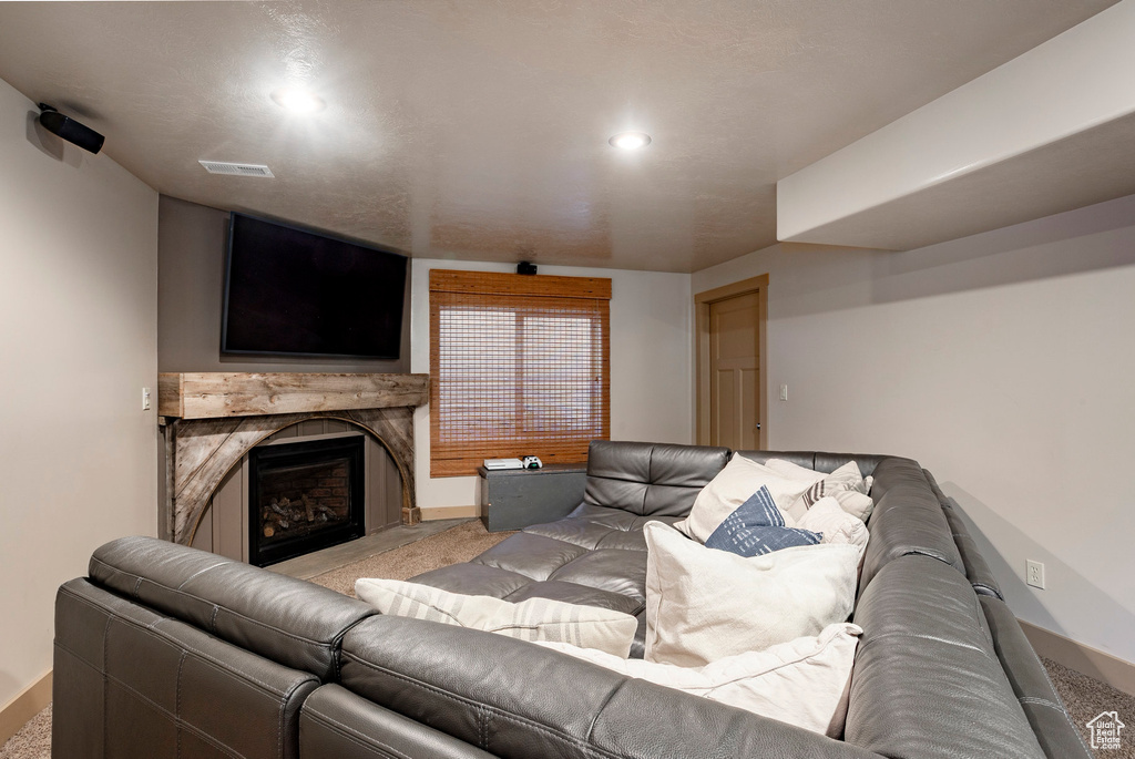 Living area with light carpet, a fireplace, and recessed lighting