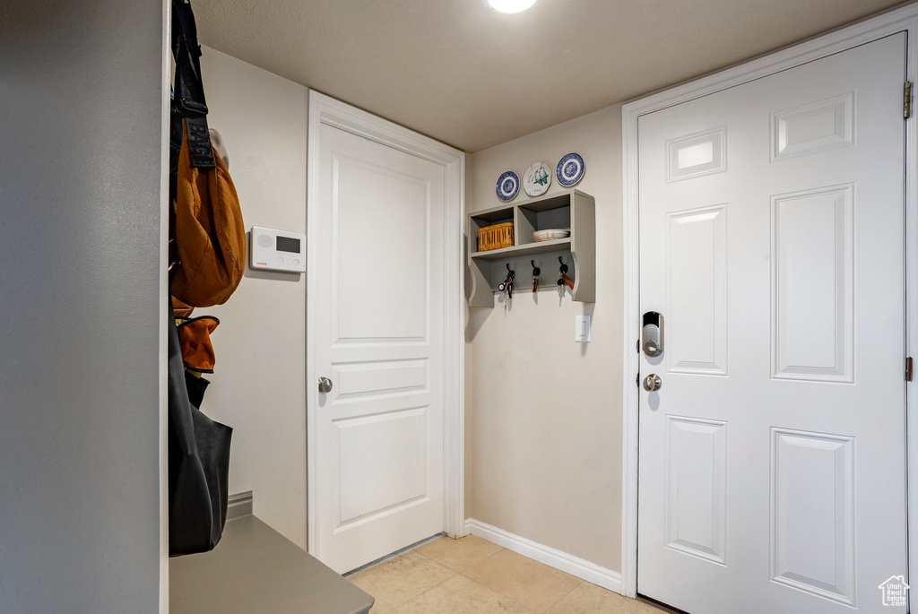 Mudroom with light tile patterned floors and baseboards