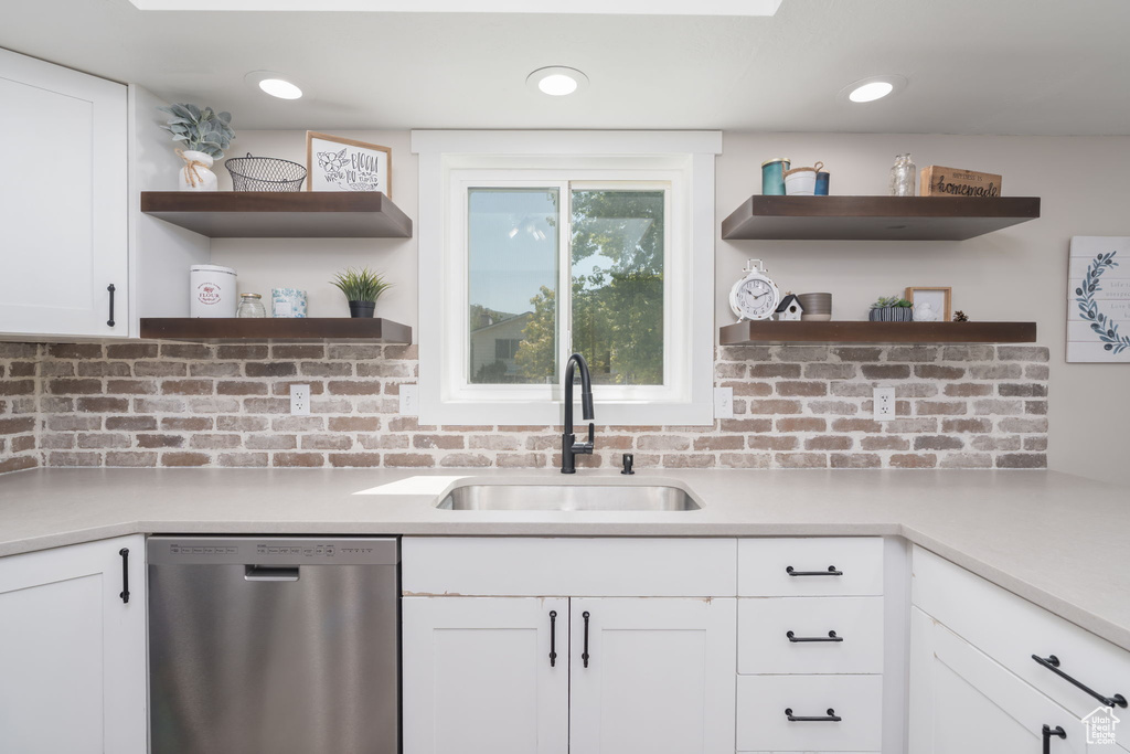 Kitchen featuring dishwasher, open shelves, white cabinetry, and tasteful backsplash