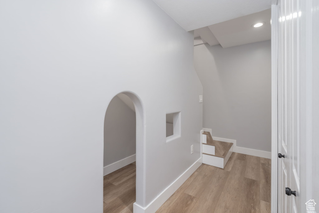 Corridor with light wood-style flooring and recessed lighting