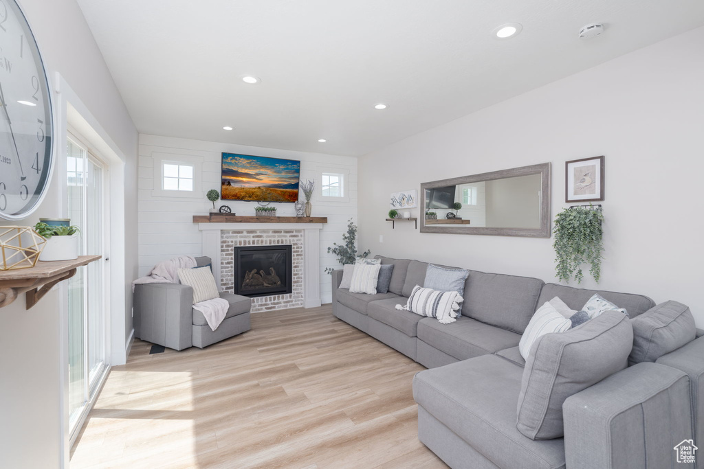 Living area featuring light wood-style floors, a fireplace, and recessed lighting