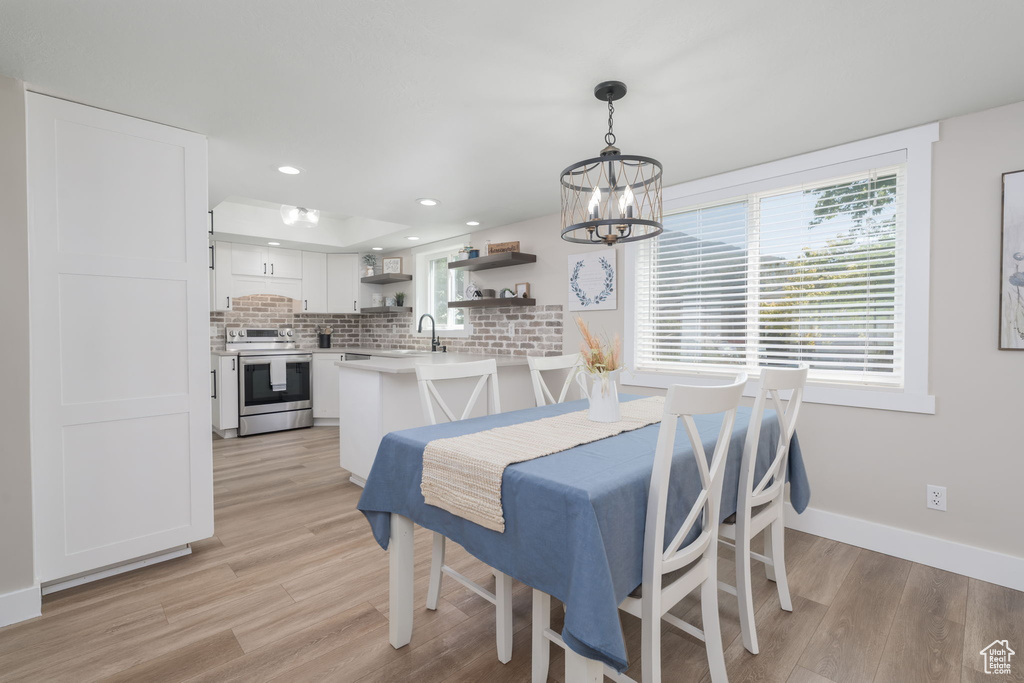 Dining area featuring light wood-style flooring, a chandelier, healthy amount of natural light, and recessed lighting