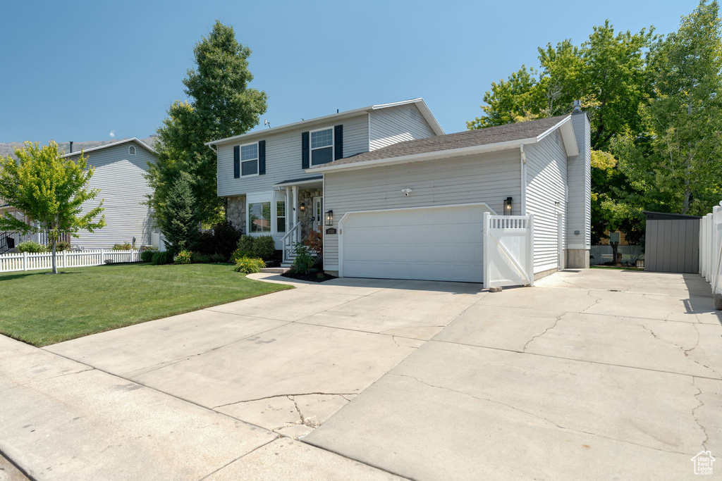 View of front of property with an attached garage, concrete driveway, and a chimney