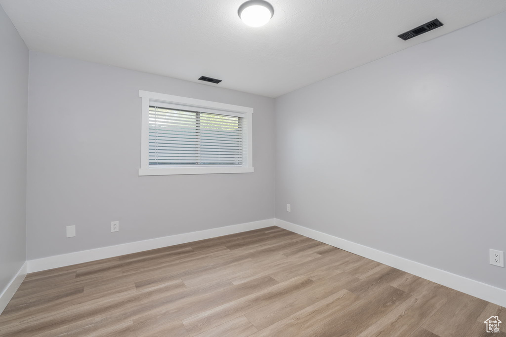 Spare room featuring light wood-type flooring and baseboards