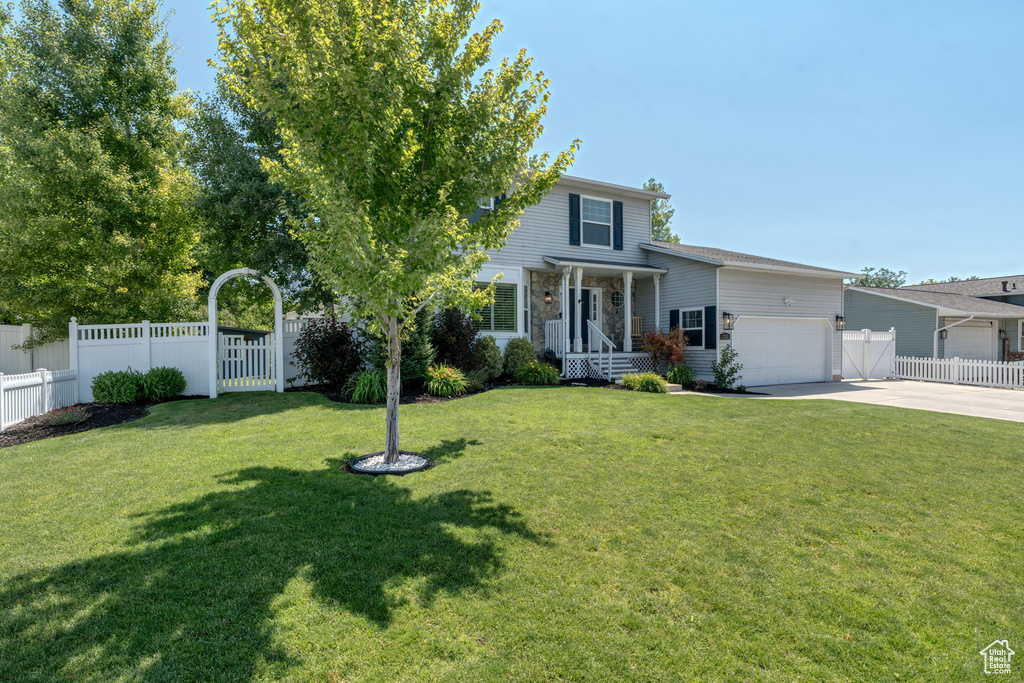 View of front of home featuring driveway, an attached garage, and a gate