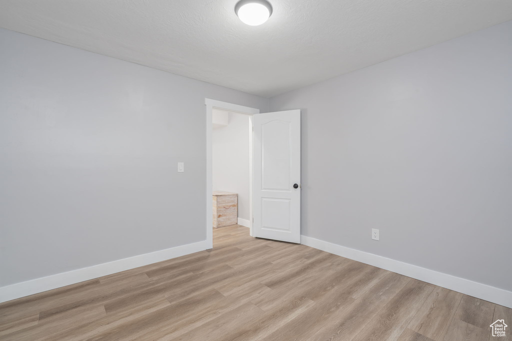 Spare room featuring light wood-type flooring and baseboards