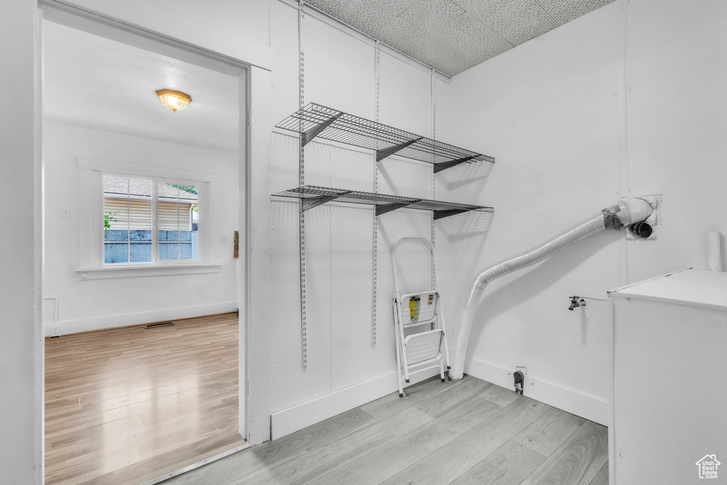 Walk in closet with light wood-style flooring
