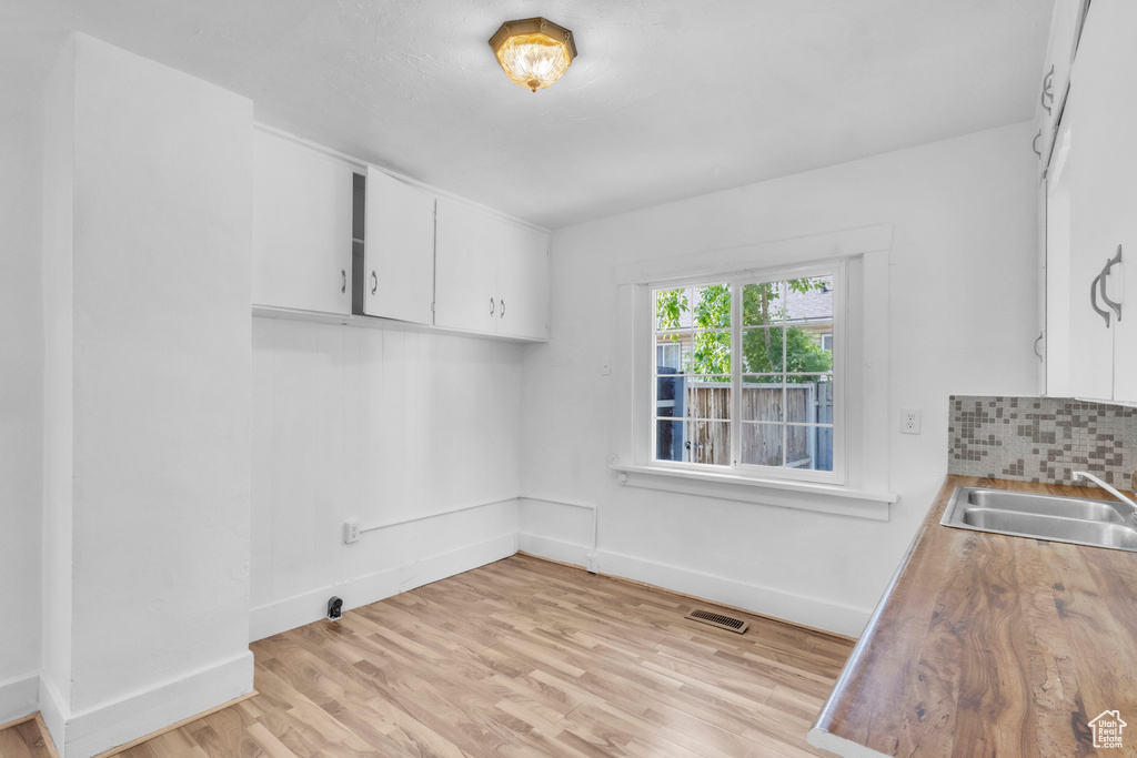 Unfurnished dining area with a sink and light wood-type flooring