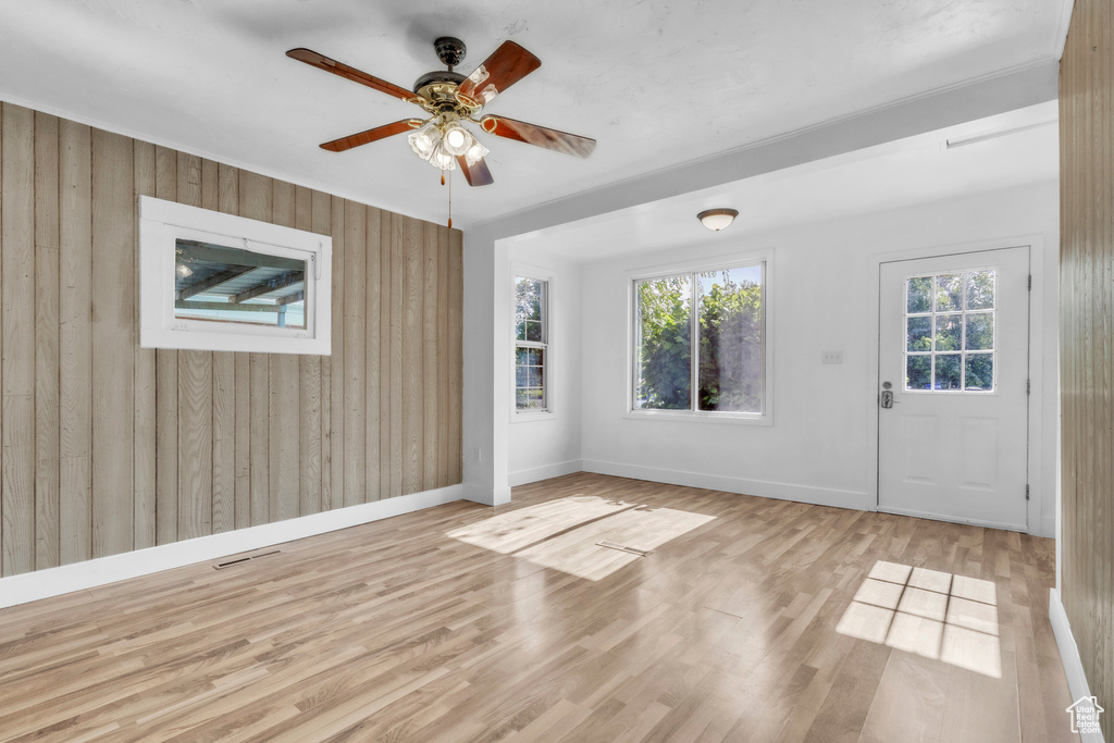 Entryway featuring wood walls, wood finished floors, and ceiling fan